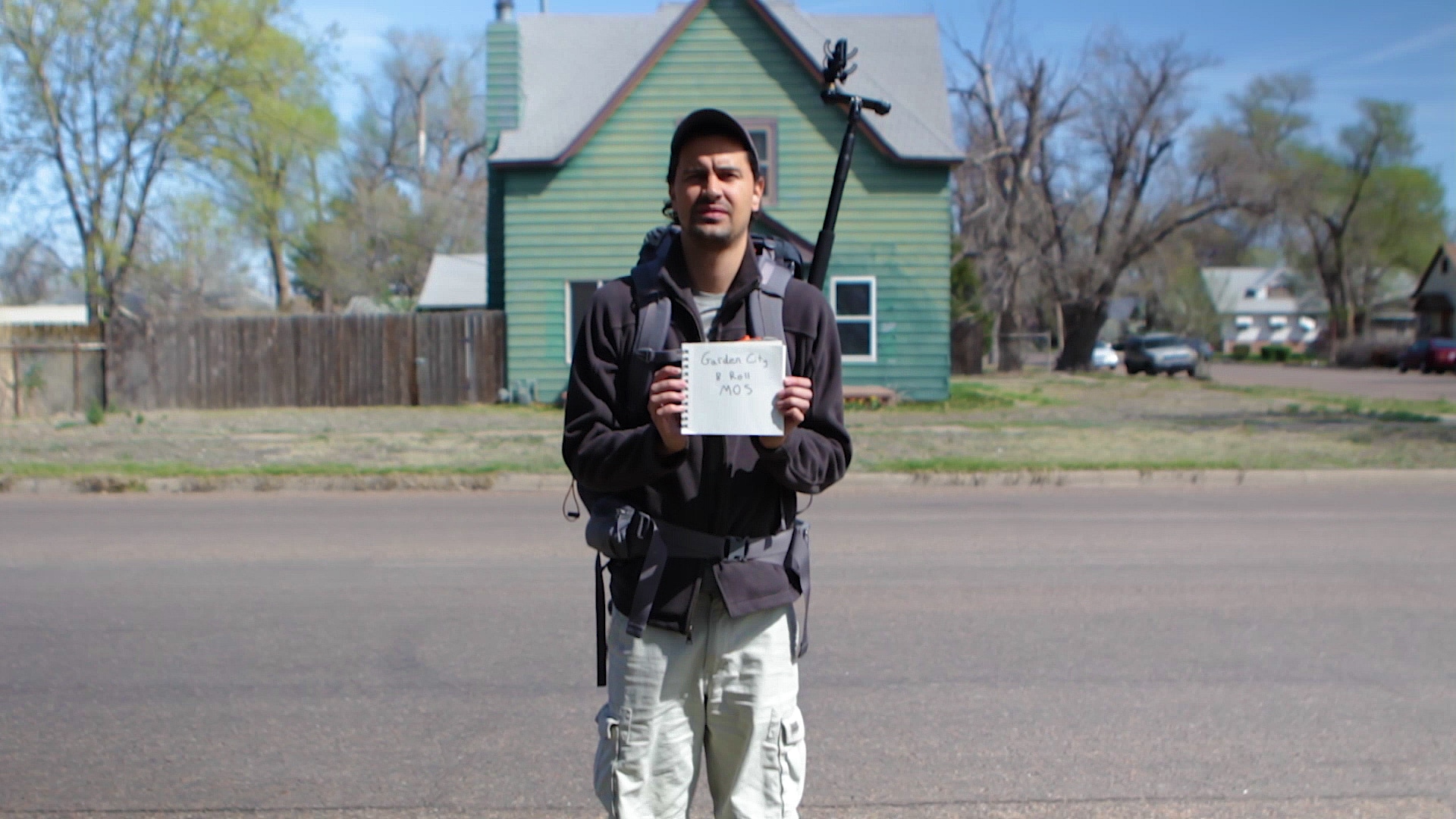 A person holding small poster in hands with some text over it.