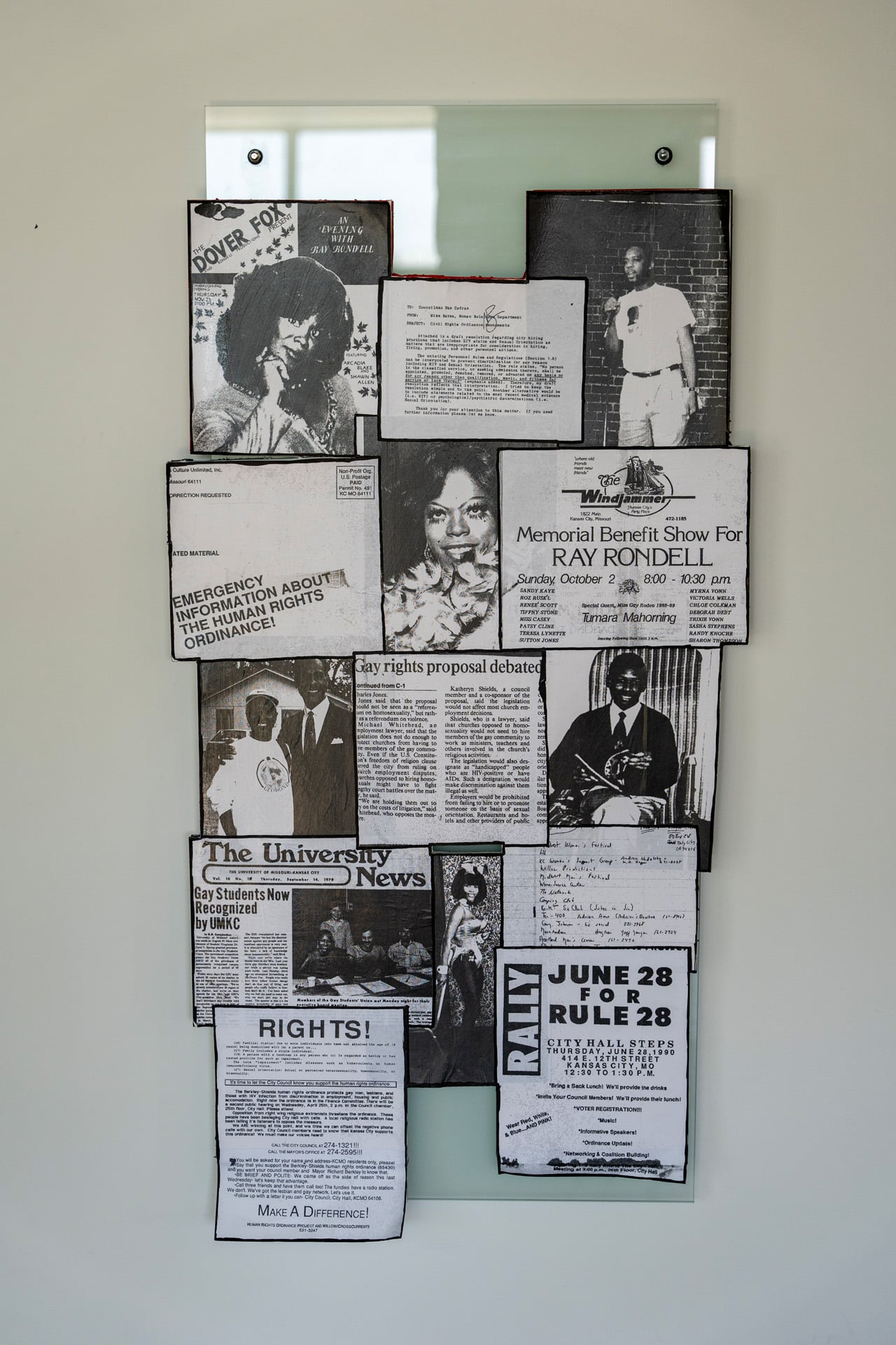 a collage on wall of fliers from the Kansas City queer community