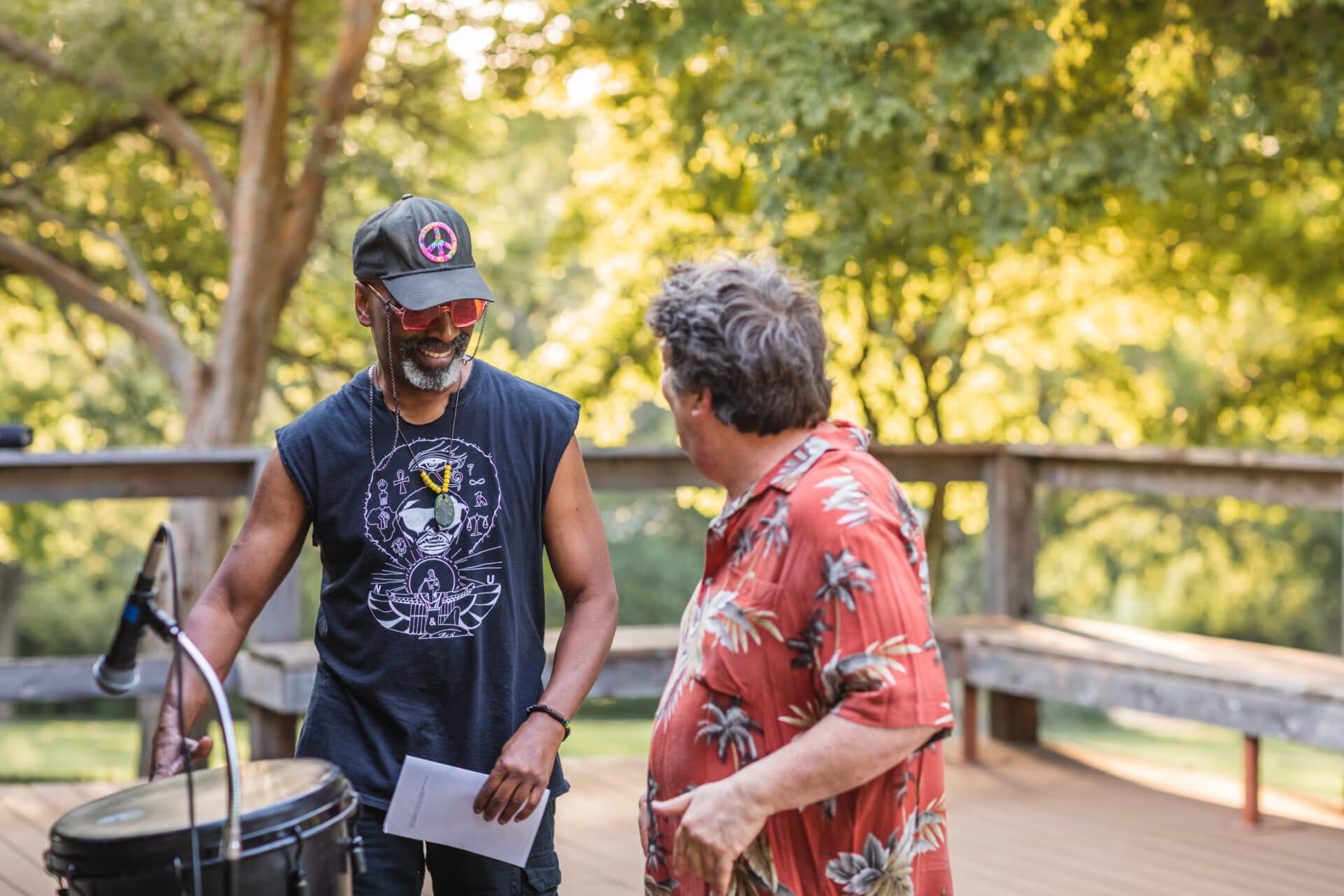 2 people communicating with a drum in foreground