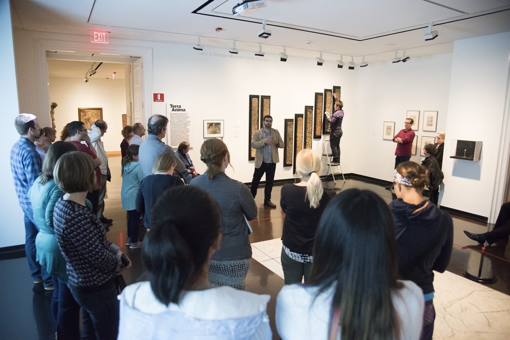 a group of people listening to the lecturer in spencer museum of art