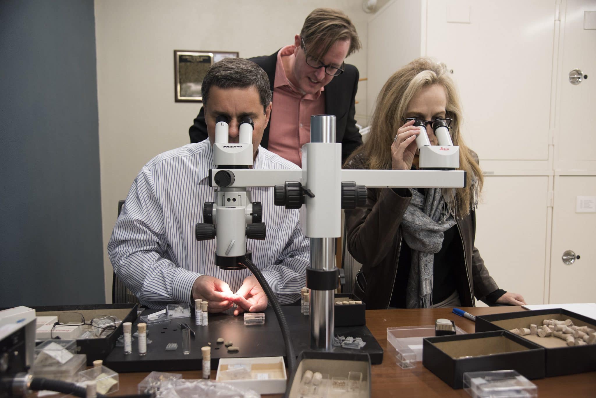 2 people looking through microscope