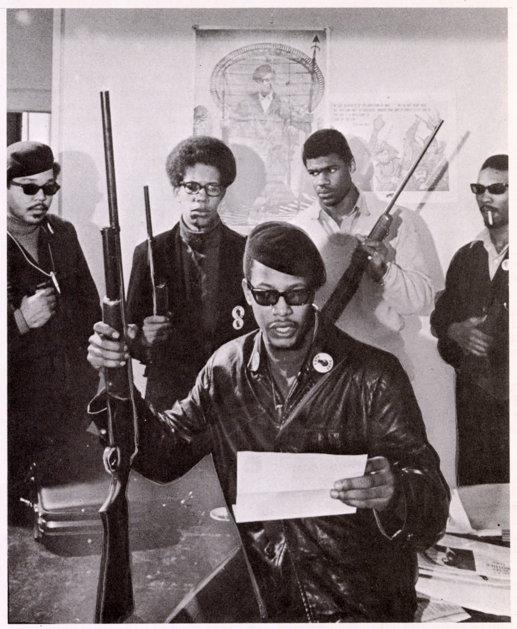 a black and white image of 5 people with gun in their hand