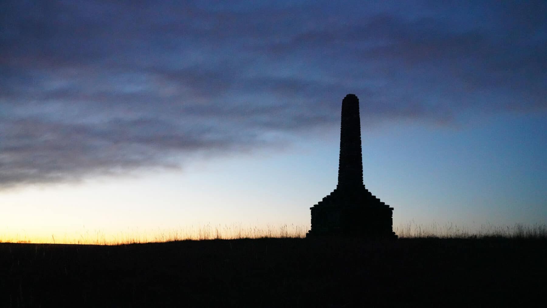 A silhouette of a chimney at sunset