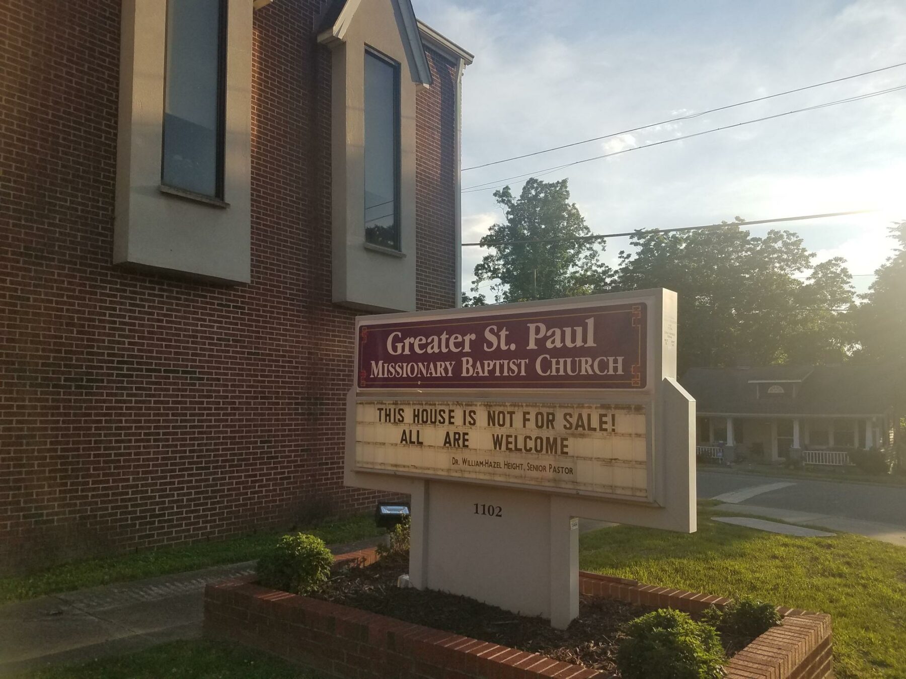 A church with a sign in front that says "This house is not for sale! All are welcome"