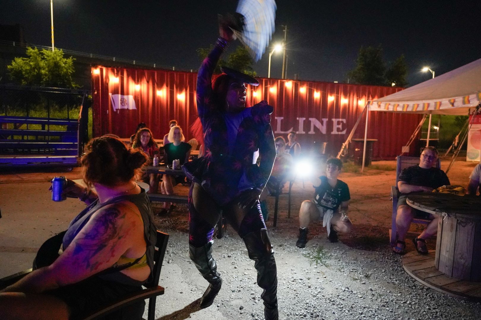 A person dancing for a crowd outside at night