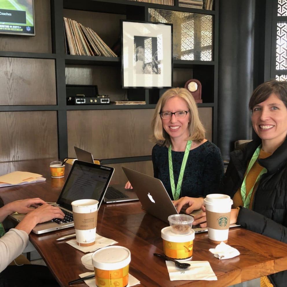 people in meeting with coffee over table.