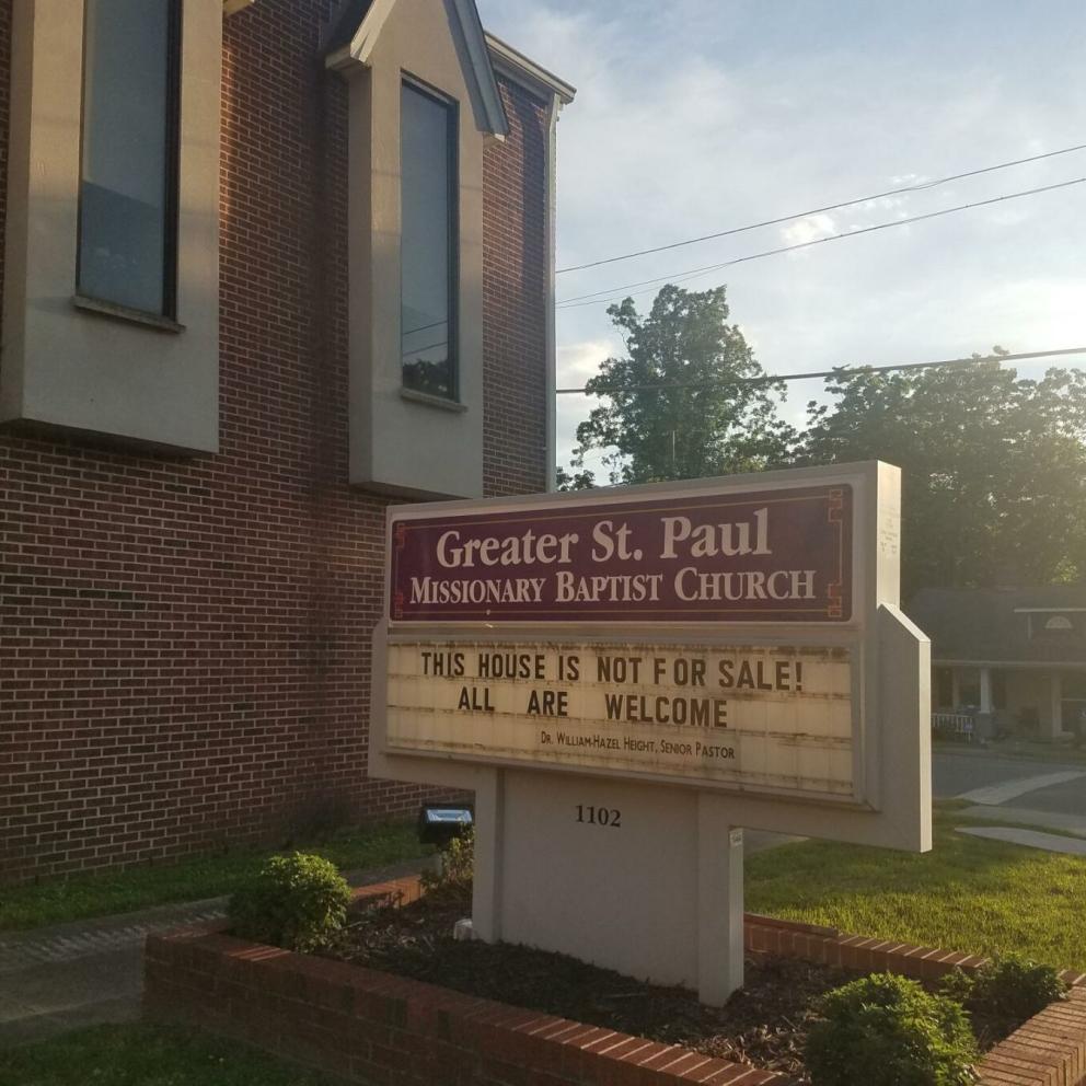 A church with a sign in front that says "This house is not for sale! All are welcome"